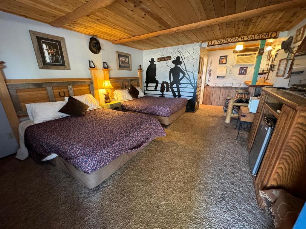 a bedroom with two beds and a tv in a room at Stagecoach 66 Motel by Capital O in Seligman