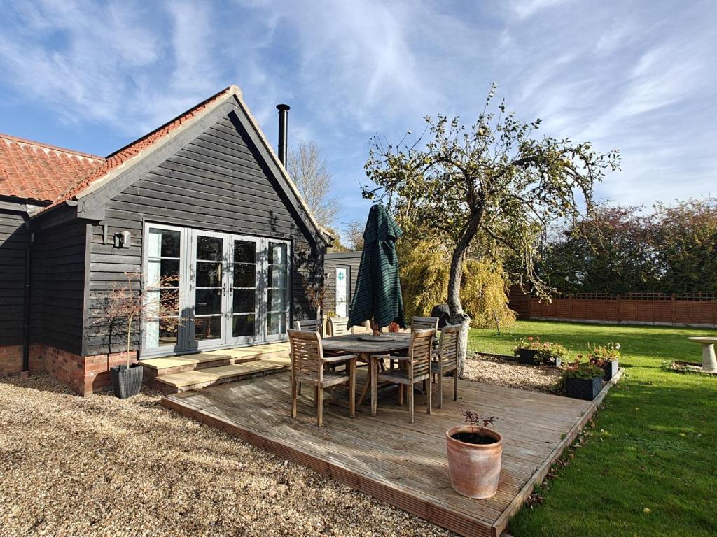 a wooden deck with a table and chairs in a yard at 1 Bed in Langmere oc-m33974 in Dickleburgh
