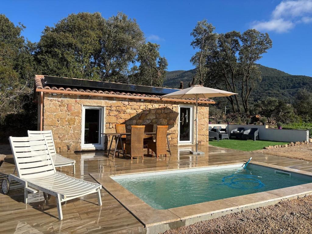 a patio with a pool and chairs and a house at Bergerie du Riccio avec piscine privée in Cauro