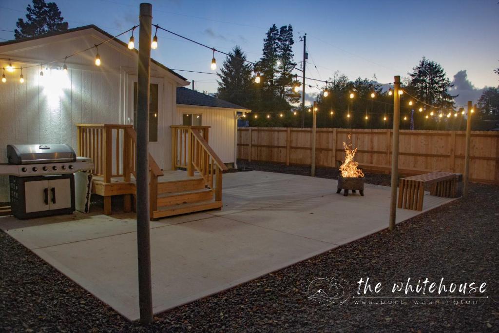 a backyard with a fire pit and a fence with lights at Westport Whitehouse in Westport