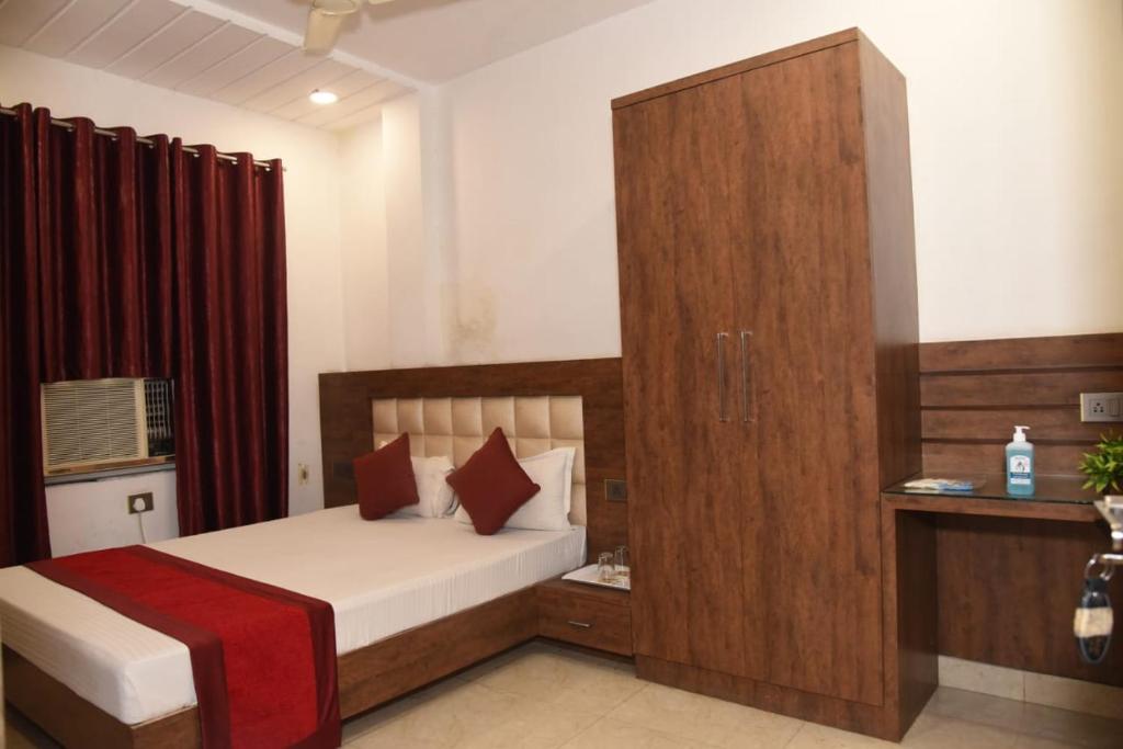 a bedroom with a bed and a large wooden cabinet at Hotel New M I Plaza in Gaya