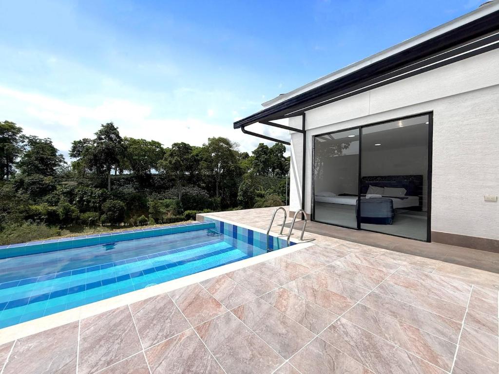 a swimming pool in the backyard of a house at Villa adhara in Quimbaya