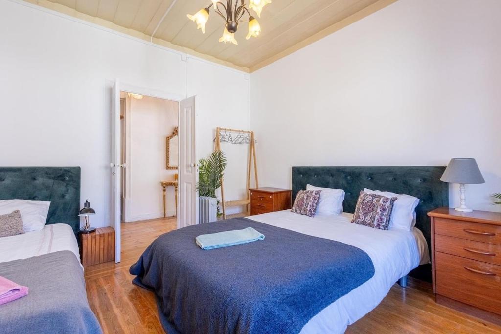 a bedroom with two beds and a dresser at Salvaterra de Magos in Salvaterra de Magos