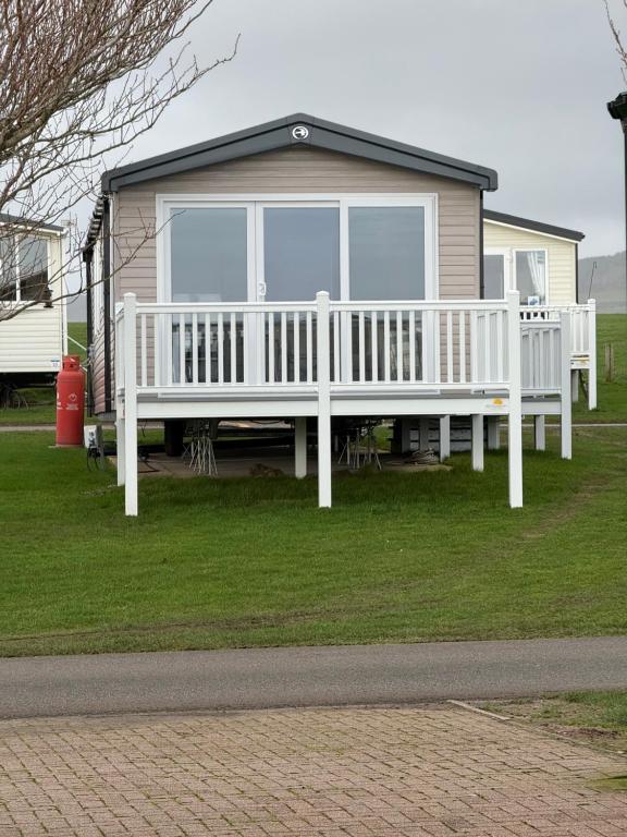a house with a white porch with a large window at Paws a while in Mainsriddle