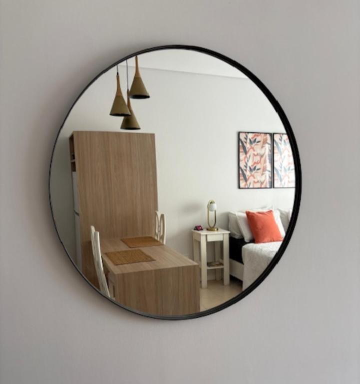 a mirror reflecting a living room with a table and a couch at Studios Montevideo in Buenos Aires