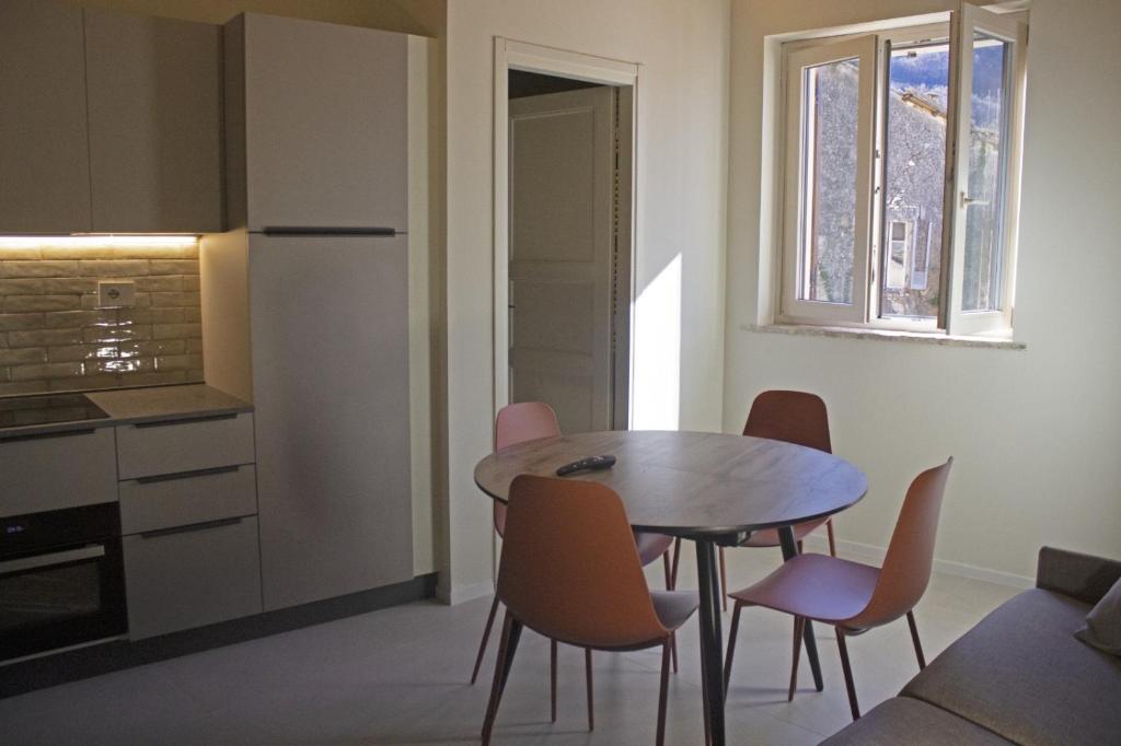 a kitchen with a table and chairs in a room at Appartamento PALE 2 posti letto in Pale