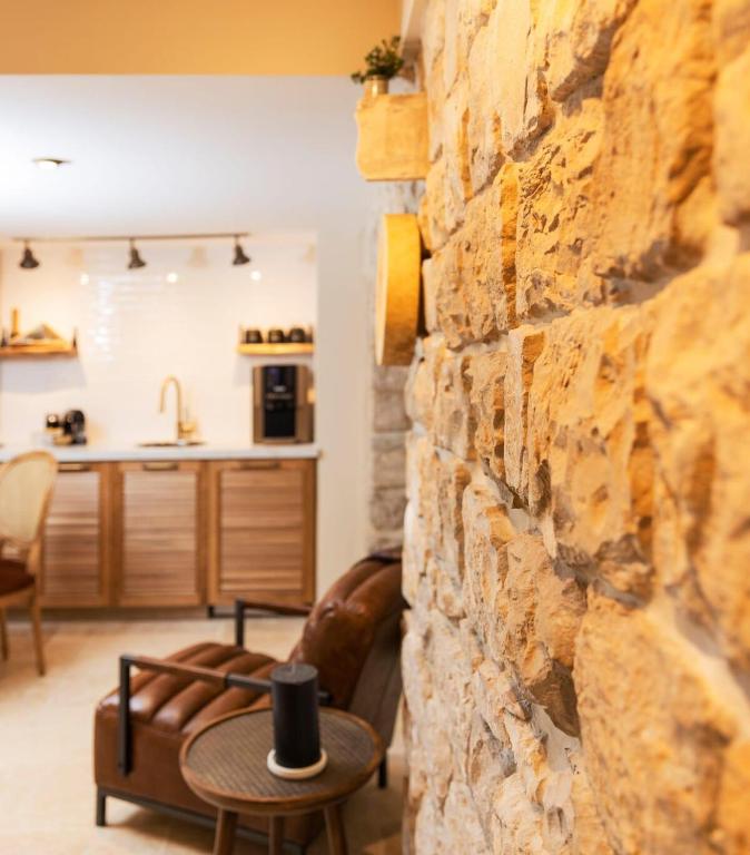 a living room with a stone wall and a table at המילטון 2 - Hamilton 2 in Safed