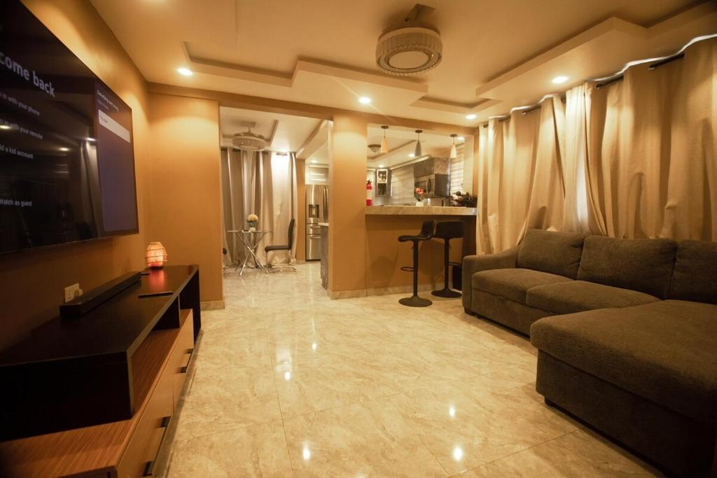 a living room with a couch and a television at Classic Apartment at Tema Community 26 in Tema