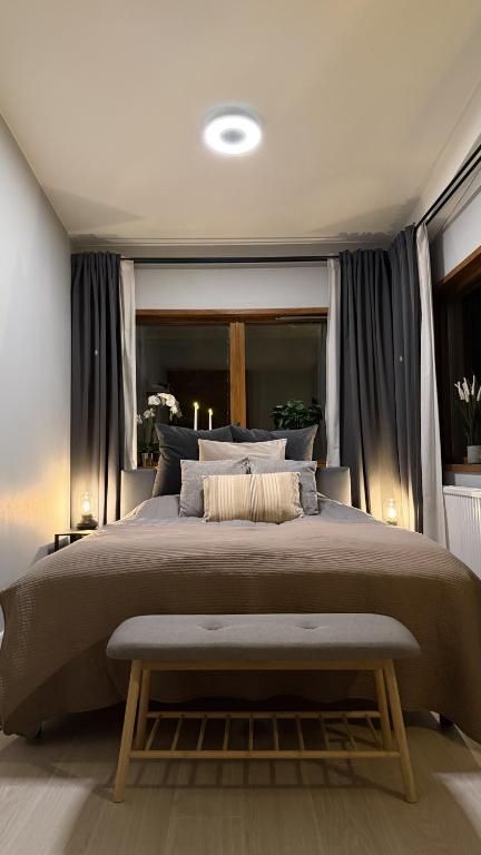 a bedroom with a large bed with a bench in it at Villa Bäckagård Bed and Breakfast in Åstorp