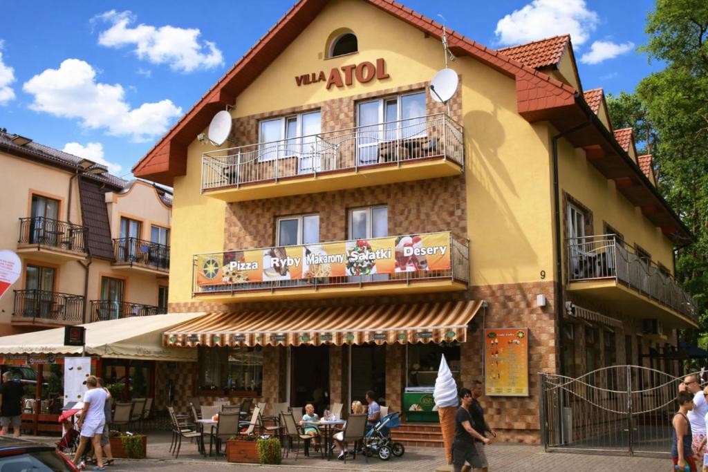 a building with people standing outside of it at Villa Atol in Niechorze