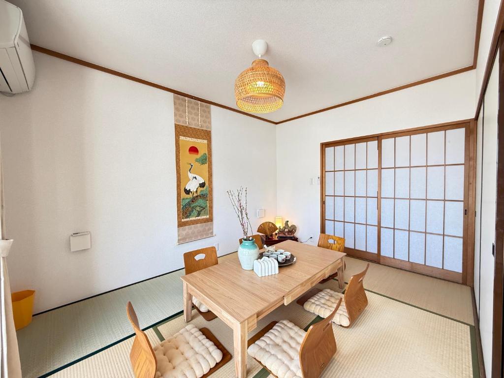 a dining room with a wooden table and chairs at 禅 宮島 一棟貸し 最大6名 ダブルベット3台 2階建の1棟貸しホテル in Hatsukaichi