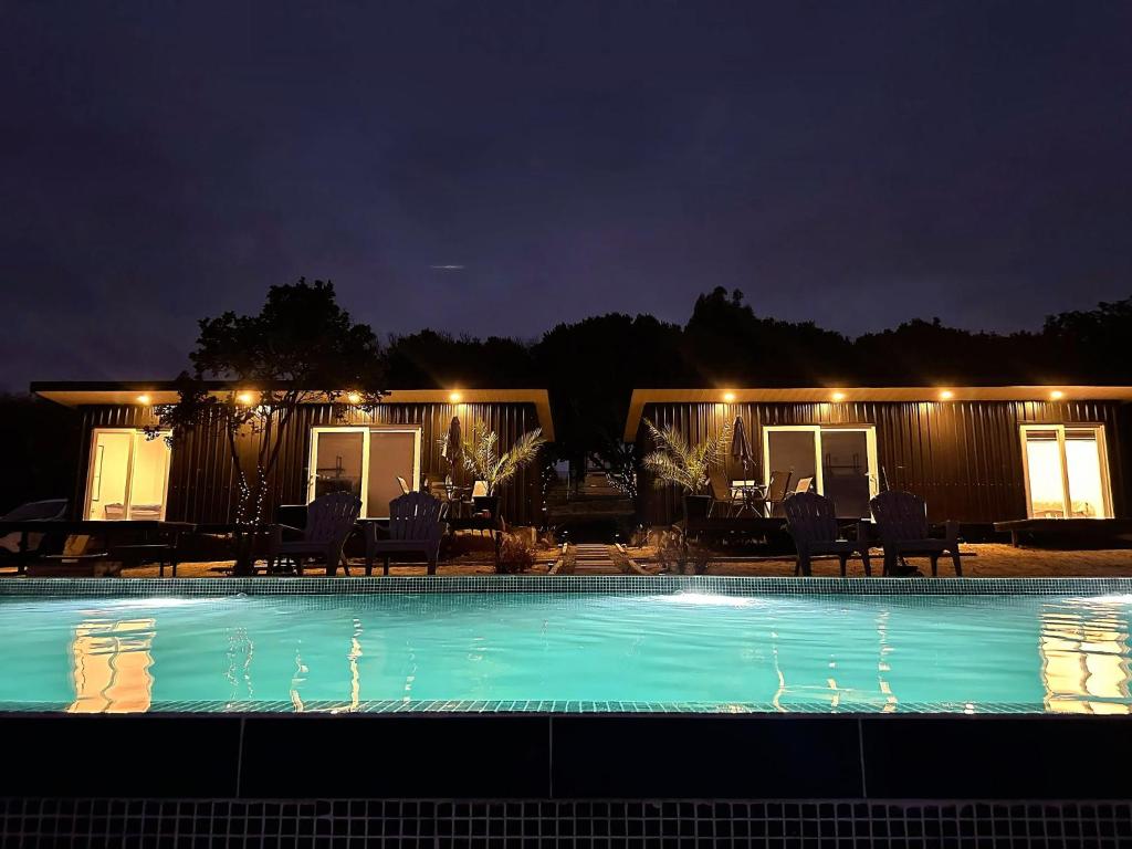 a swimming pool at night with chairs and lights at Tordos Lodge in Quintero
