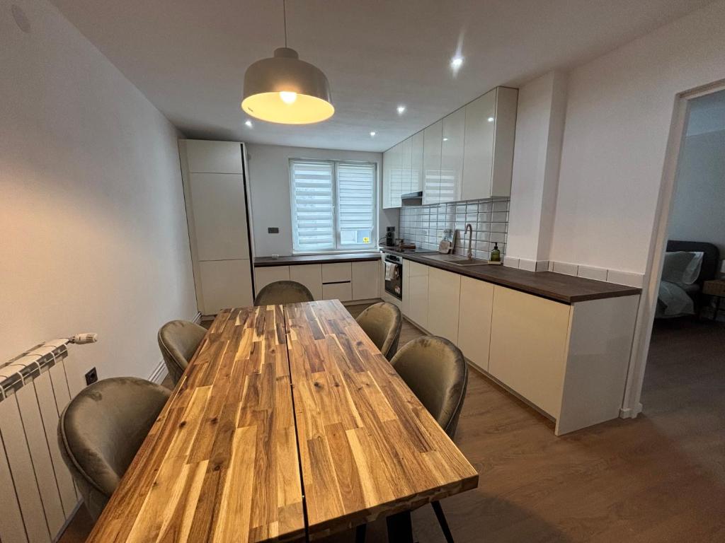 a kitchen with a wooden table and some chairs at Clock in Gheorgheni
