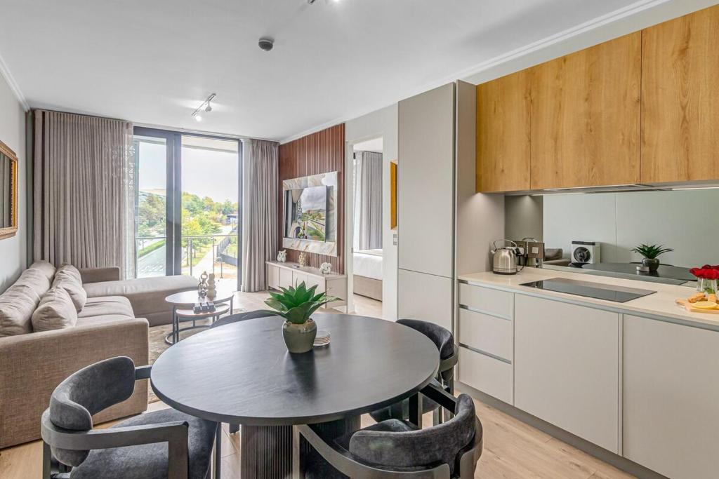 a kitchen and a living room with a table and chairs at Heatherstone Haven in Midrand