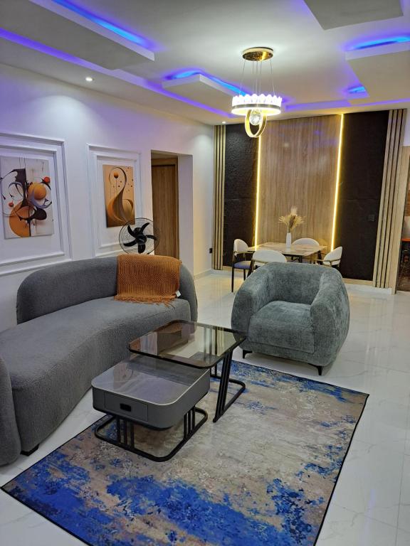 a living room with two couches and a table at Diolux Comfy Apartments in Sangotedo