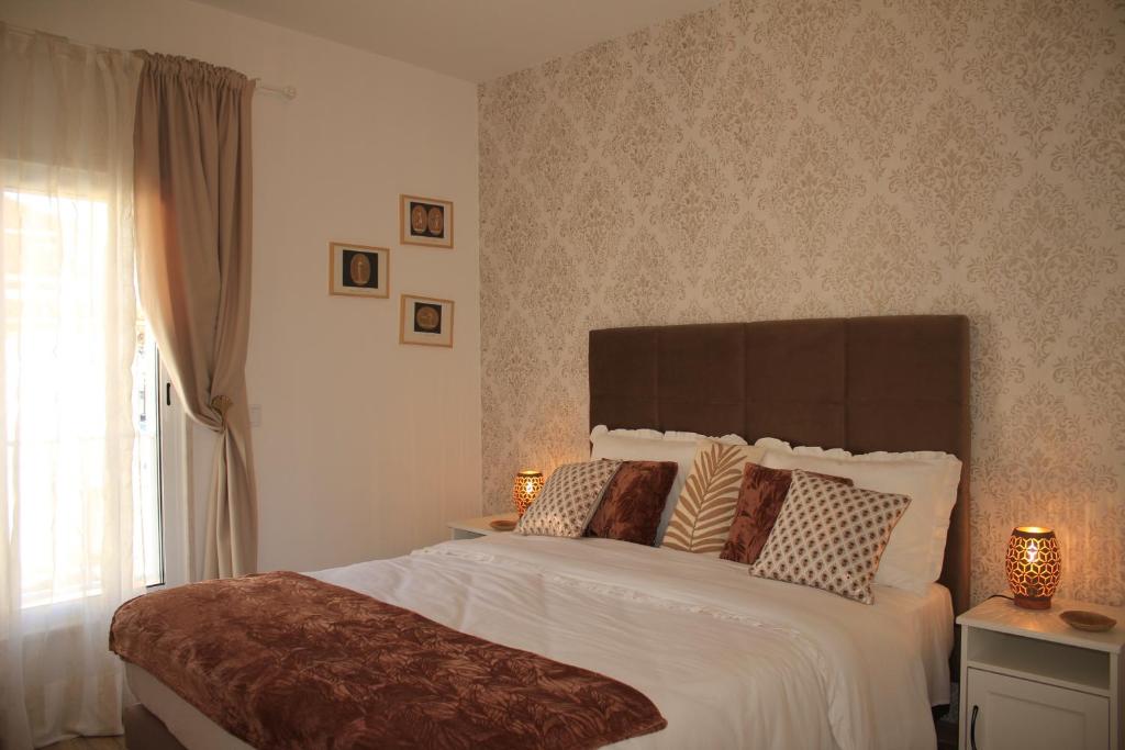 a bedroom with a large white bed with pillows at Vila Prata Dourada 1 in Ferreira do Zêzere