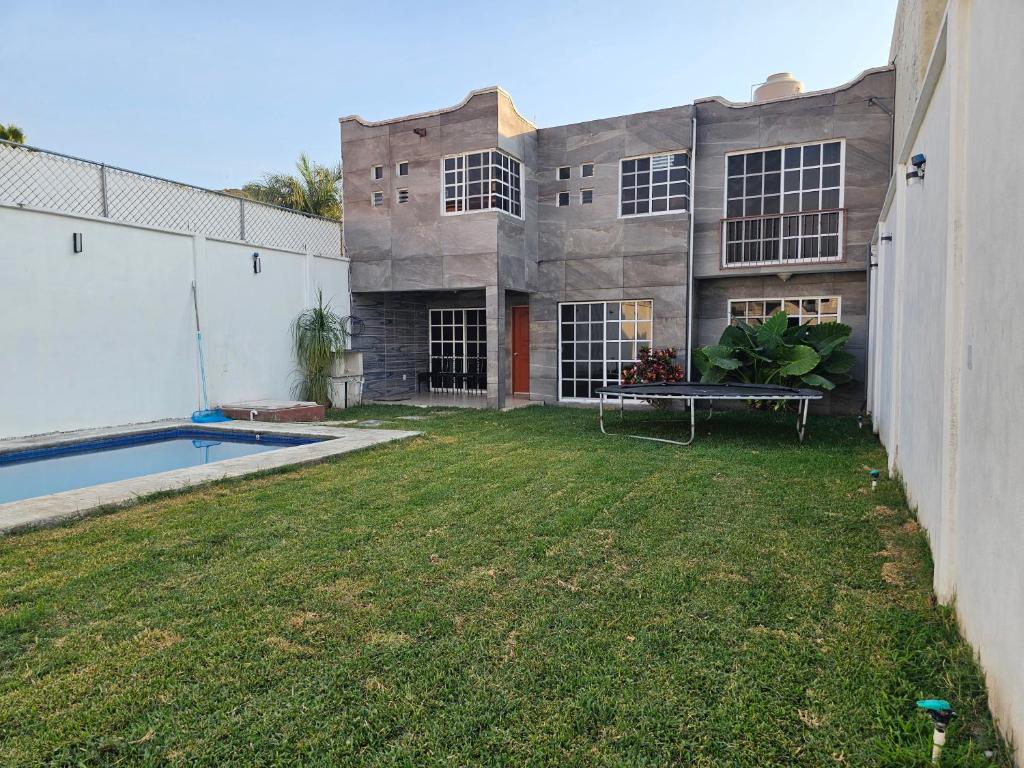 a building with a yard with a swimming pool at Las fincas Jiutepec in Jiutepec