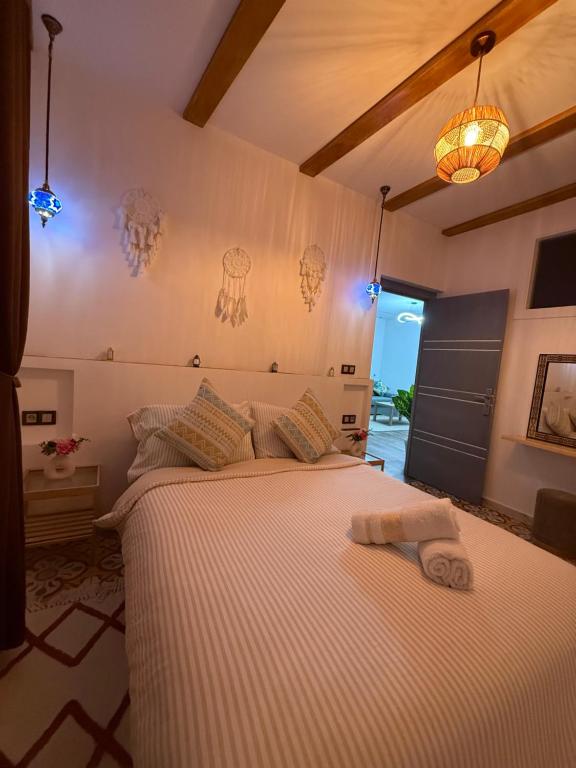 a bedroom with a large bed with a white blanket at Dar Diamante Azul in Chefchaouen
