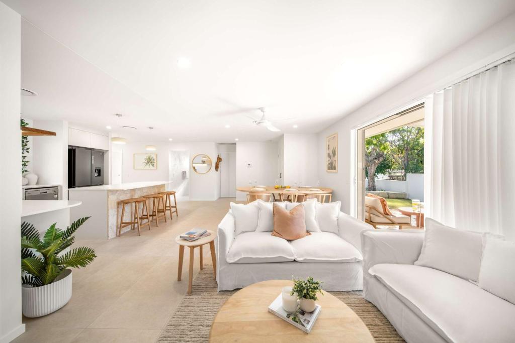 a living room with a white couch and a table at Solara Escape Mooloolaba - Luxe Pet-Friendly Home in Alexandra Headland