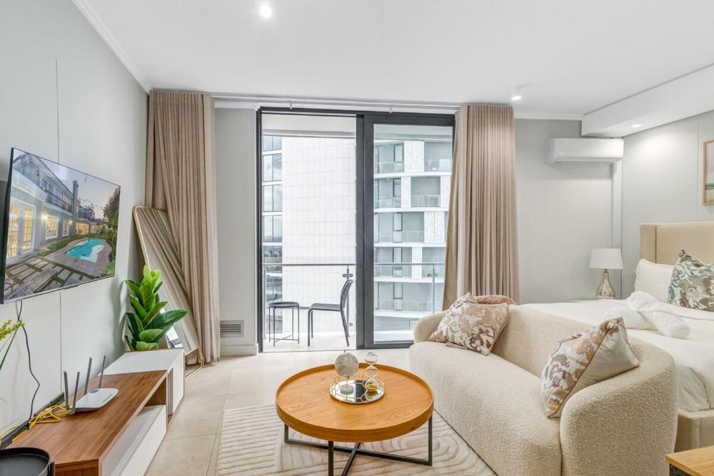 a living room with a couch and a table at Solitude Studio Apartment, Ellipse, Midrand in Midrand