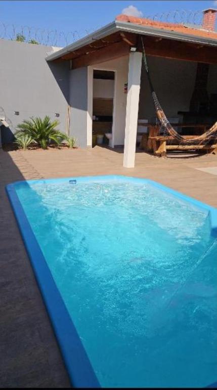 a blue swimming pool in front of a house at JMS Refuge in Pirapora