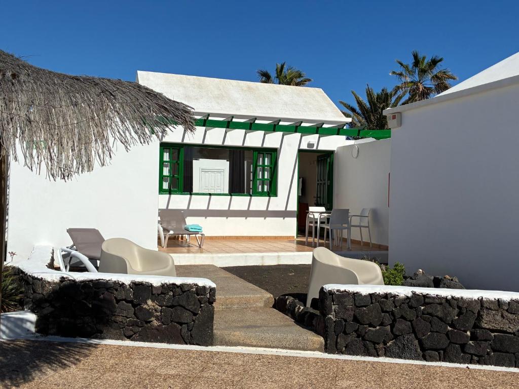 a white house with chairs and a patio at CASA MACA sea view & beach front in Puerto del Carmen