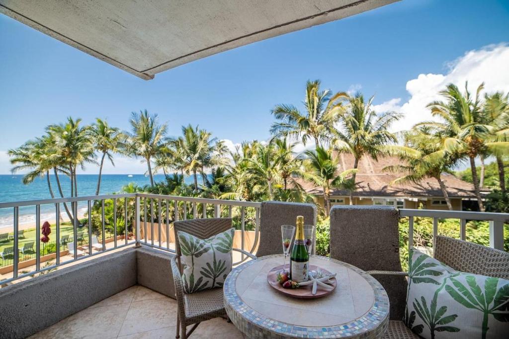 a balcony with a table and chairs and the ocean at Nani Kai Hale 308 in Kihei