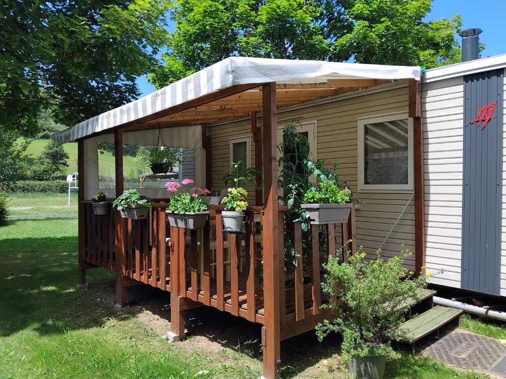 a gazebo with potted plants on it at Monpetitmobilhome in Ascarat