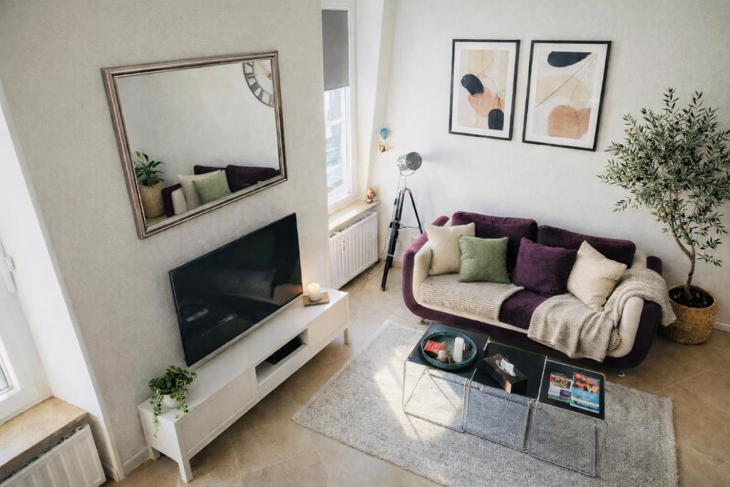 a living room with a couch and a mirror at Charming & Cosy duplex - city in Luxembourg