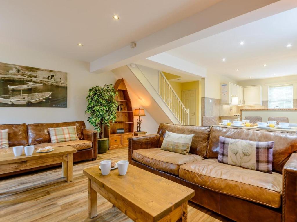 a living room with brown leather couches and a table at 3 Bed in Chathill oc-79566 in Beadnell