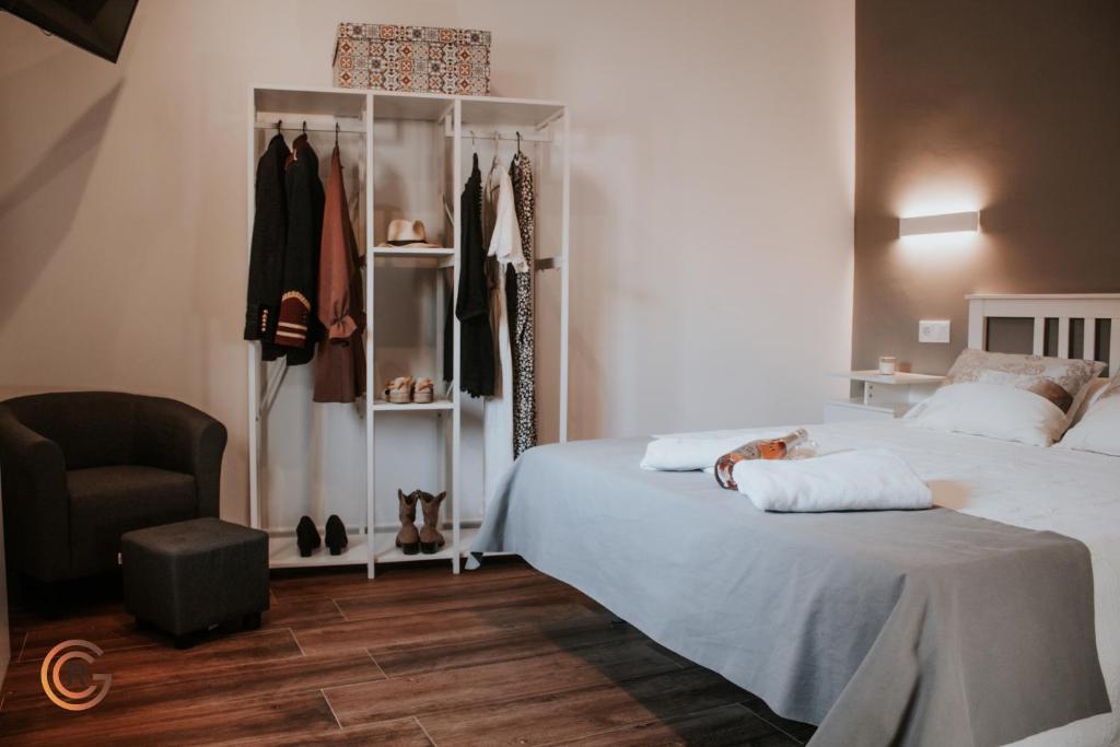 a bedroom with a bed and a chair and a closet at Apartamentos Cañón de la Rinconada in Trujillo