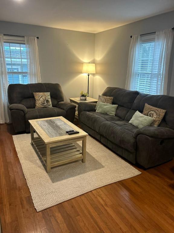 a living room with two couches and a coffee table at Under the Oaks, A Downtown Hidden Gem in Wilmington