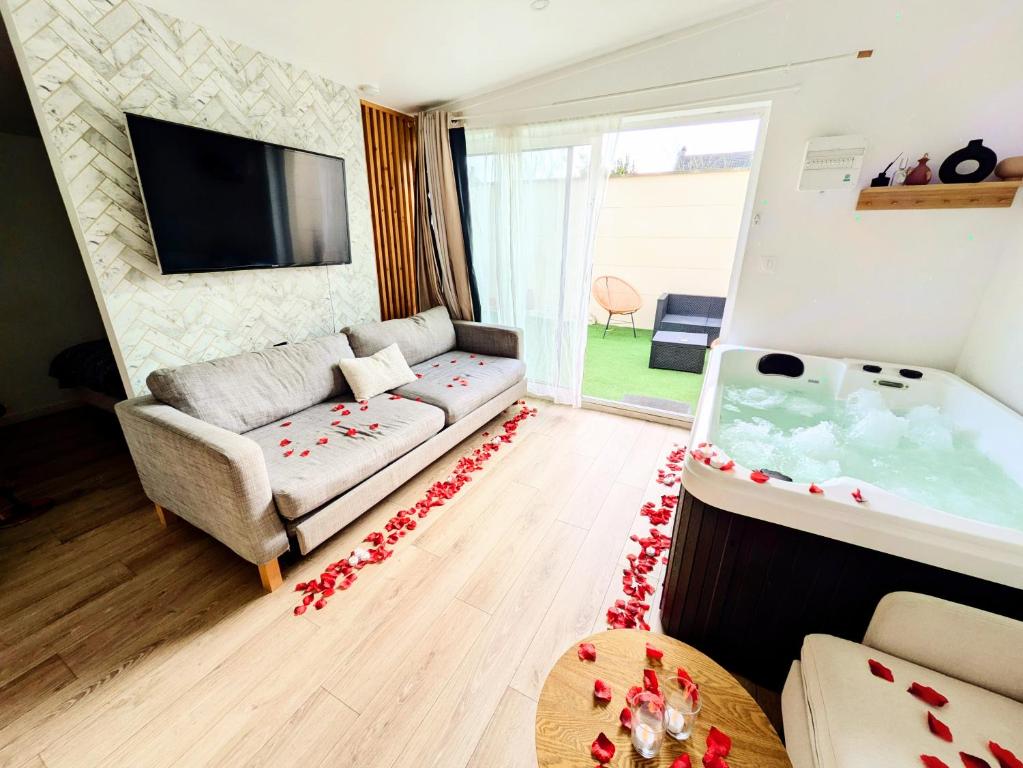 a living room with a couch and a large tub at Suite Évasion Spa - Tiny House in Vernouillet