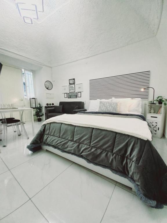 a bedroom with a large bed in a white room at Marinella House Napoli centro Piazza Dante in Naples