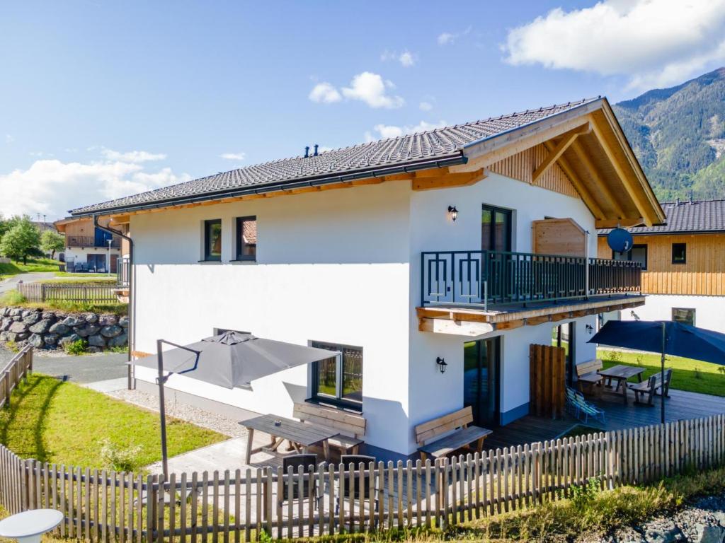 a white house with a balcony and a fence at Obermöschach 10A in Obermöschach