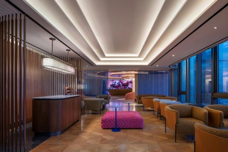 a lobby with a waiting room with chairs and tables at 마티네차움호텔 in Seoul