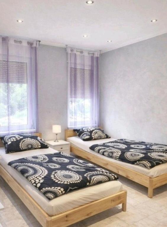 two beds in a room with two windows at Ferienwohnungen am Holzmarkt, am Rande der Altstadt in Bad Kreuznach