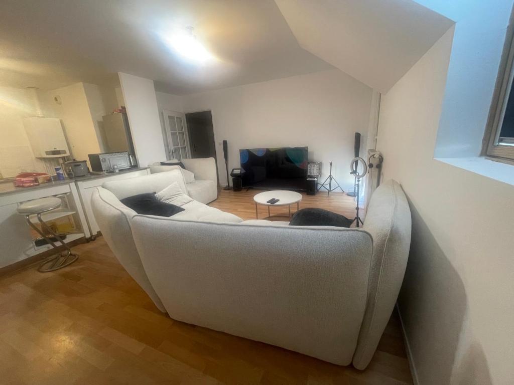 a living room with a white couch and a table at Lux 1 in Orléans