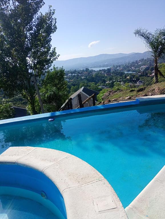 a blue swimming pool with a view at Cabañas Los Álamos in Villa Carlos Paz