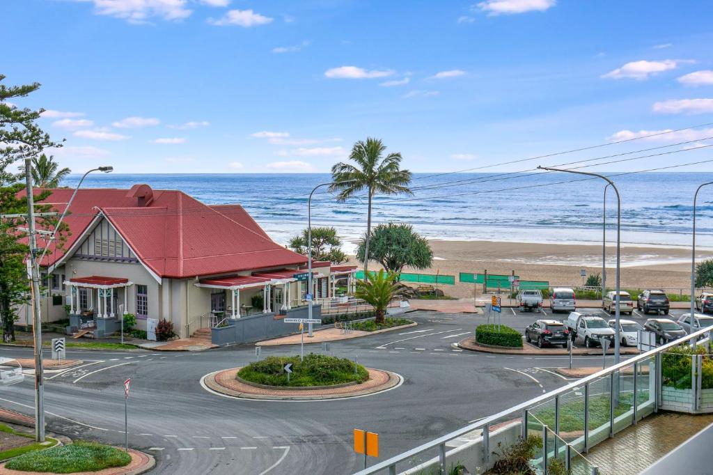 a building on the beach with the ocean in the background at Kirra Gardens Unit 9 in Gold Coast