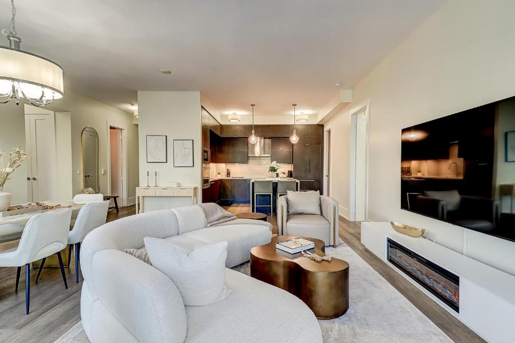 a living room with a couch and a dining room at Skyline Penthouse in Toronto