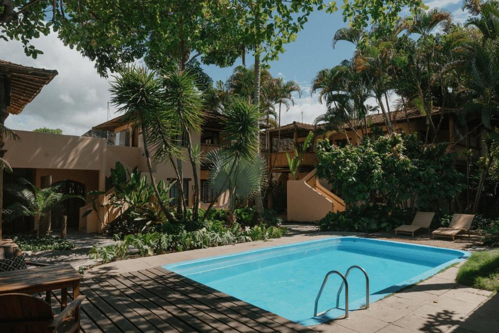 a swimming pool in the backyard of a house at Pousada Erva Doce in Arraial d'Ajuda