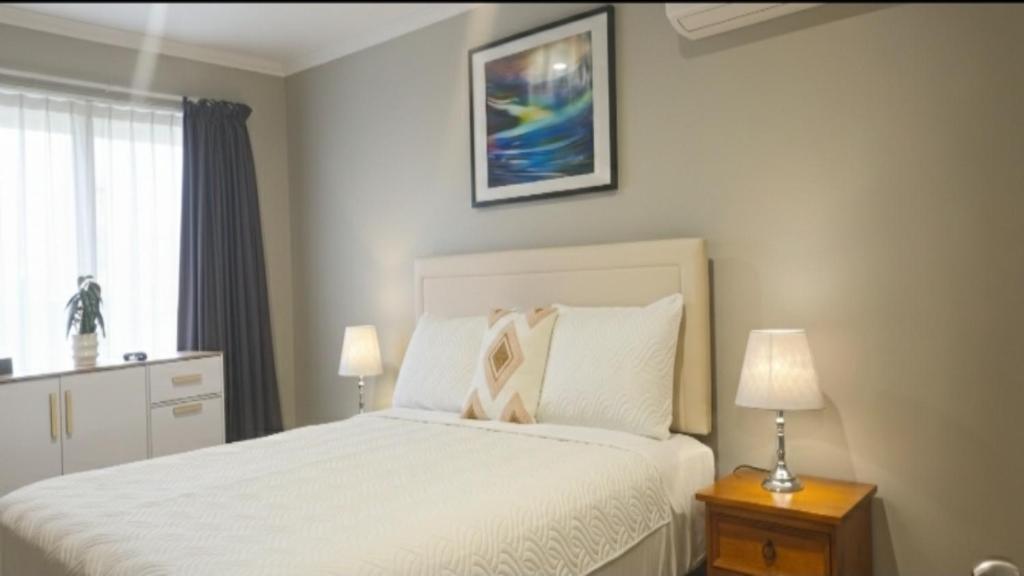 a bedroom with a white bed and a window at Stylish Tawa Retreat in Wellington