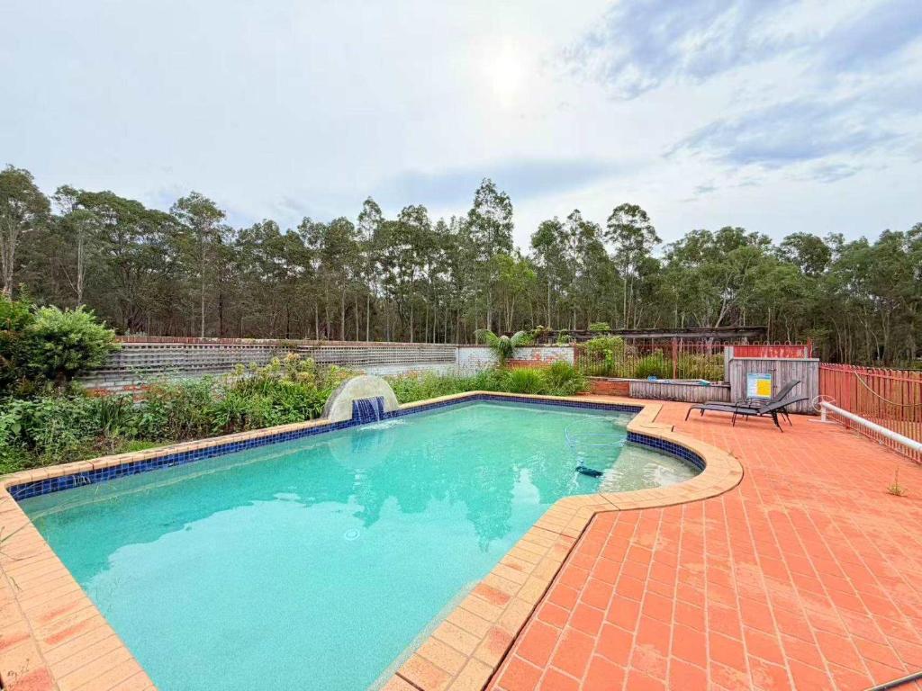 a swimming pool in a yard with a patio at Spacious Queen and Single Farmhouse Room in Worragee