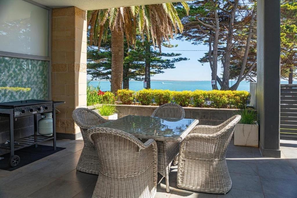 a patio with a table and chairs and the ocean at C-Scape water front apartment in Cowes