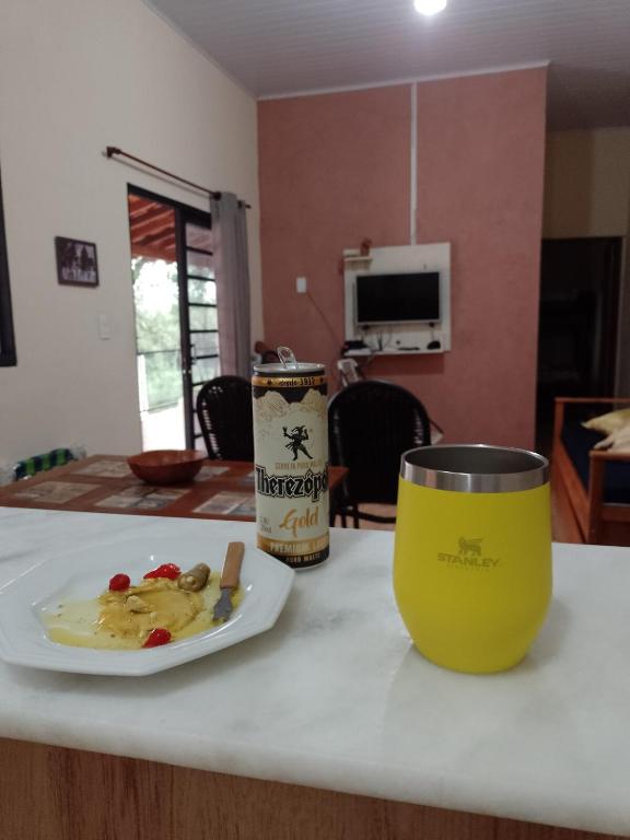 a table with a plate of food and a cup at Rancho Macalé Balneário de Rancharia Sp in Rancharia