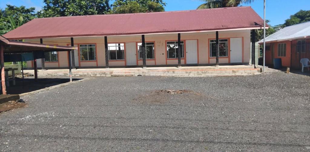 ein Gebäude mit rotem Dach und vielen Fenstern in der Unterkunft Uncle Ben's in Apia
