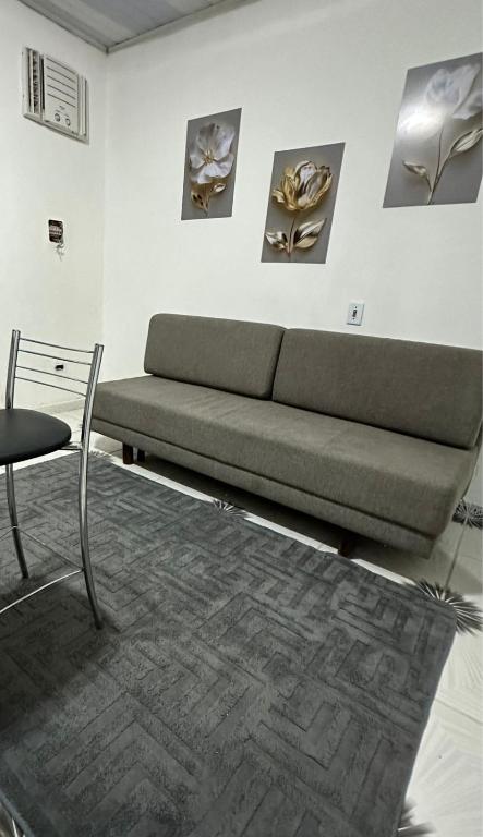 a living room with a couch and a chair at KITNET mobiliada com ar condicionado in Guarujá