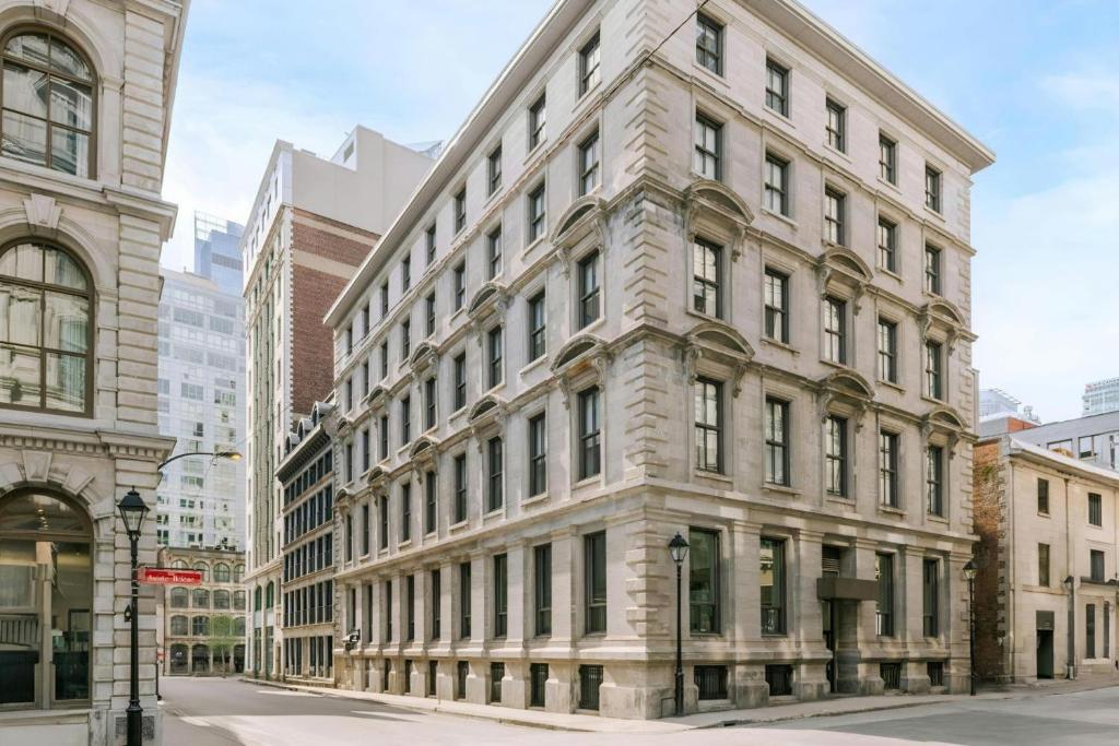 a large stone building on a city street at The Alexander - Old Montreal in Montreal