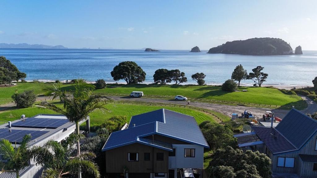 an aerial view of a house and the ocean at Hahei Beachside Escape in Hahei
